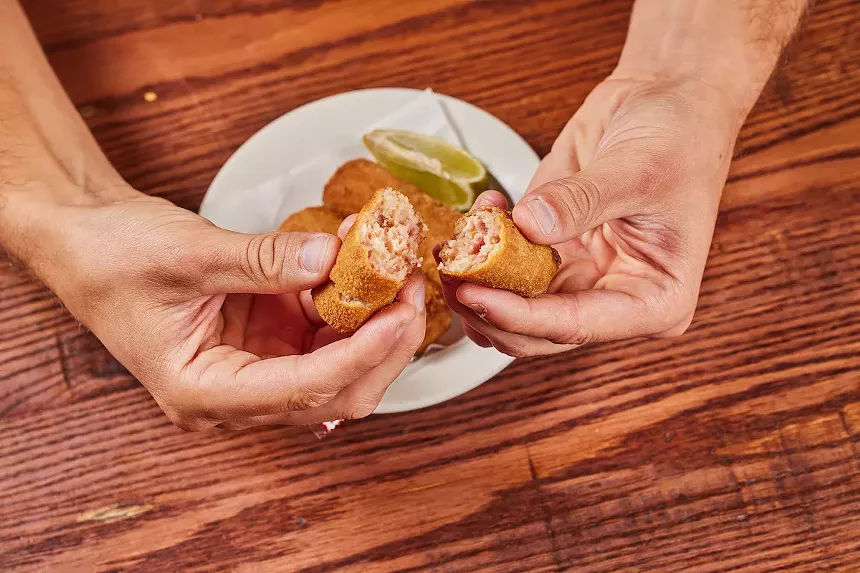 A person holding a croqueta