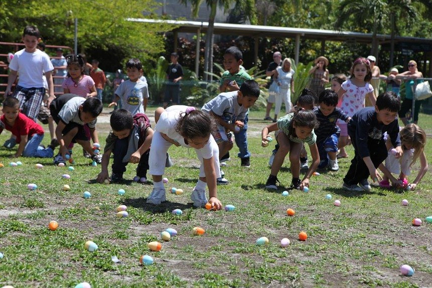 Young children picking Easter eggs from the grass