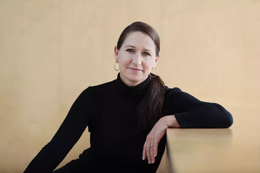 Portrait of Christine Cox leaning on her elbow in a black sweater