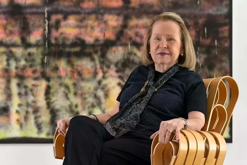 Rosa de la Cruz seated in front of a large painting