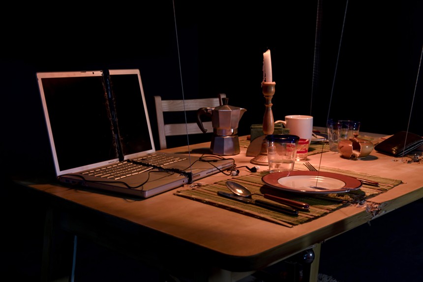 Mix-media art installation of a dining table and laptop computer
