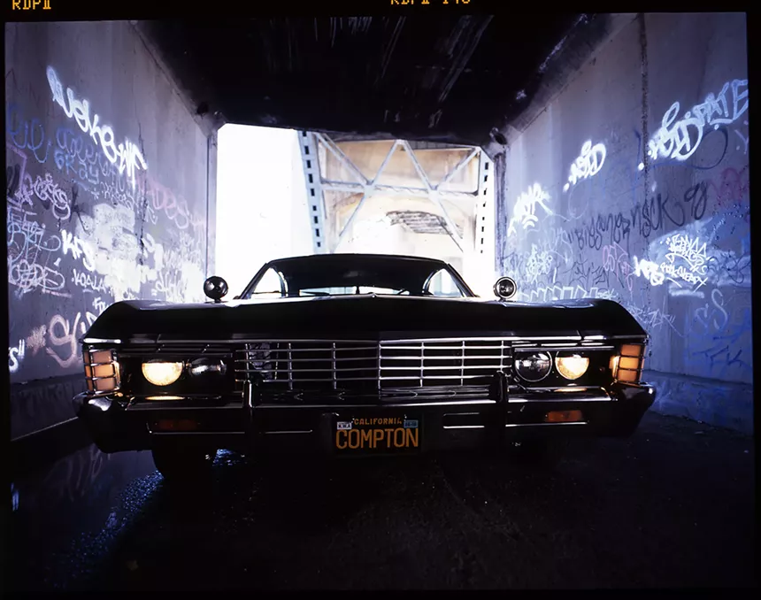 A car with a California license plate that reads Compton
