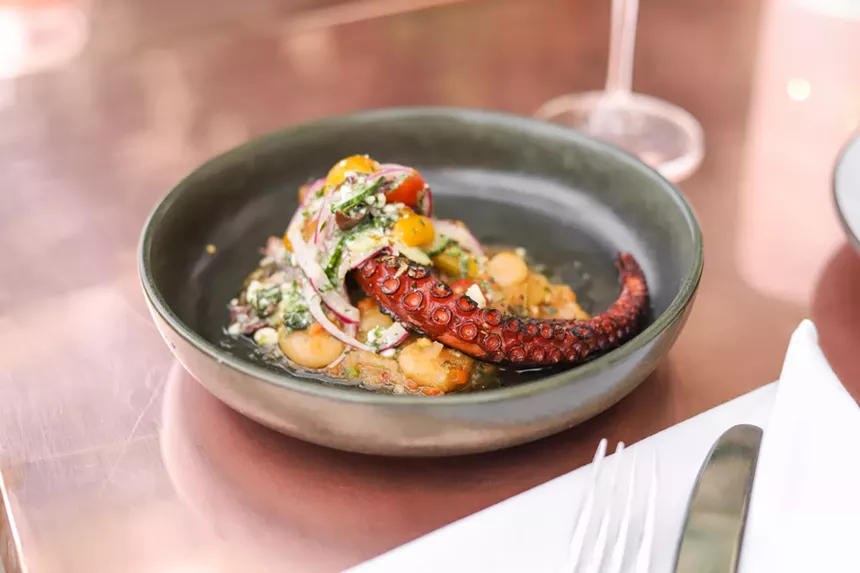 A squid dish in a blue bowl on a table