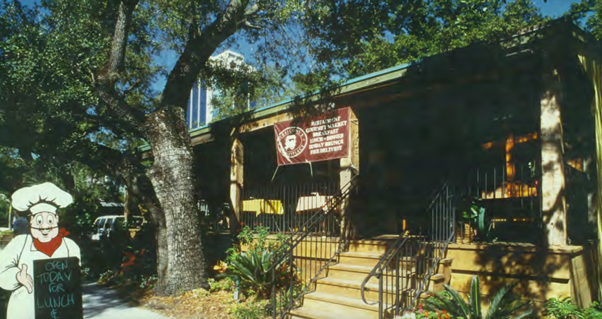 An old photograph of an old building next to trees