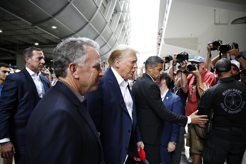 Surrounded by security, Donald Trump makes his way through the Miami International Autodrome before the 2024 Miami Grand Prix.