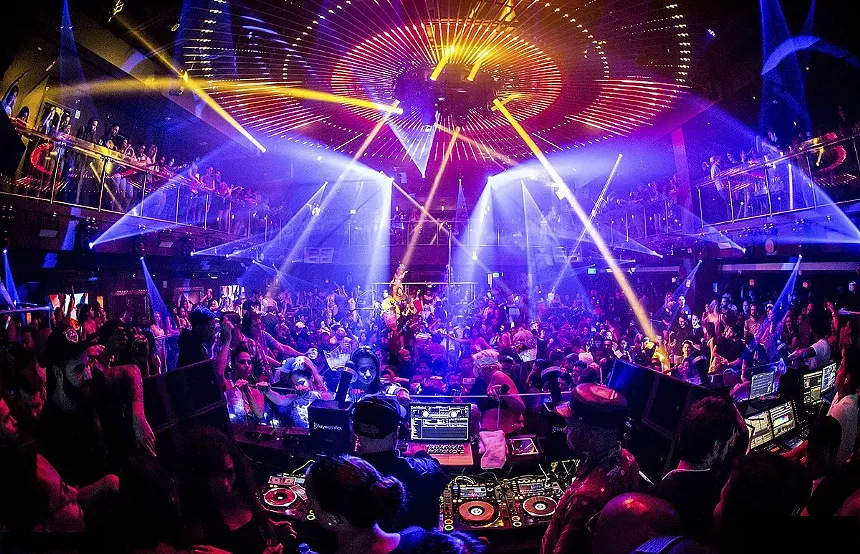 A packed venue with lights shining everywhere