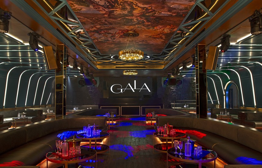 Interior of Gala with tables and DJ booth in the background