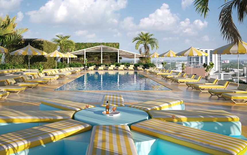 A pool with plenty of yellow and white seating around it