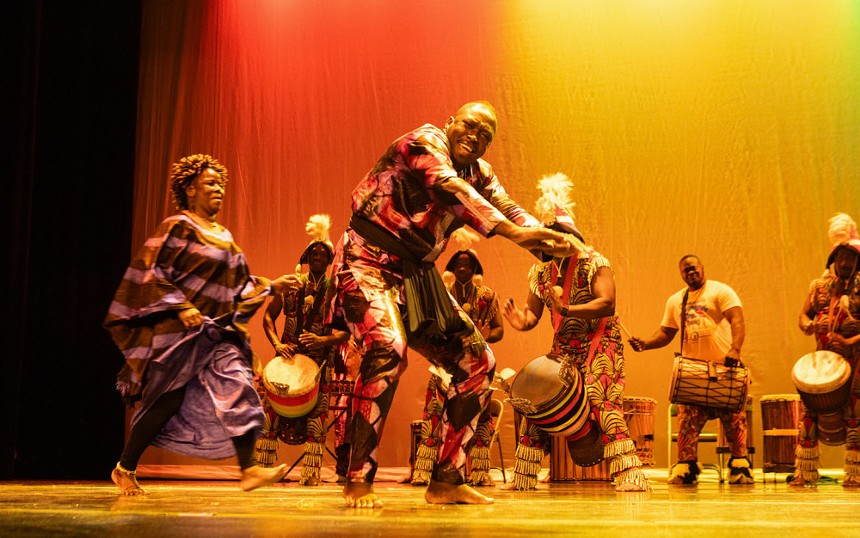 Dancers perform traditional African dance on a stage.