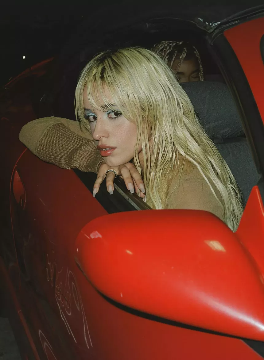 Portrait of Camila Cabello posing on a red car