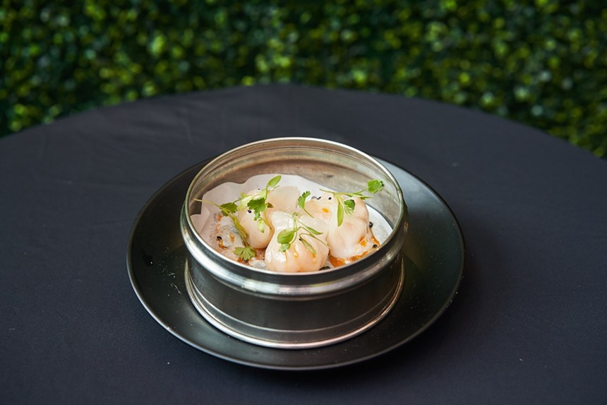a bowl of dim sum on a black table