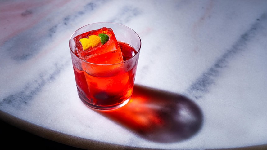 a red cocktail on a marble table