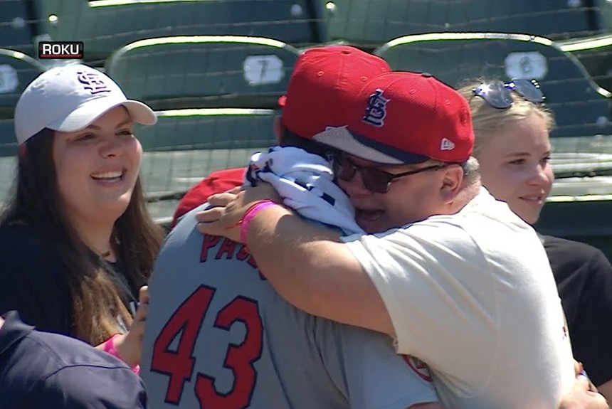 With a wide smile and a St. Louis Cardinals cap, Edgar Pagés hugs his son Pedro
