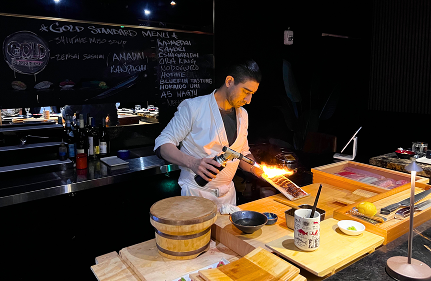 a man making sushi with a torch
