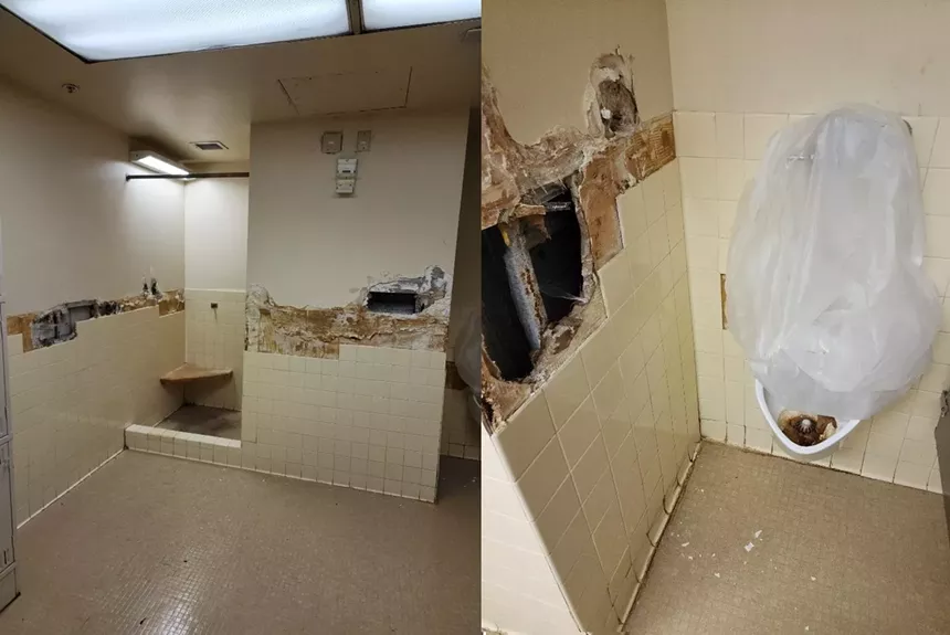 A rundown bathroom at the Miami VA with a gaping hole in the wall and stained fixtures