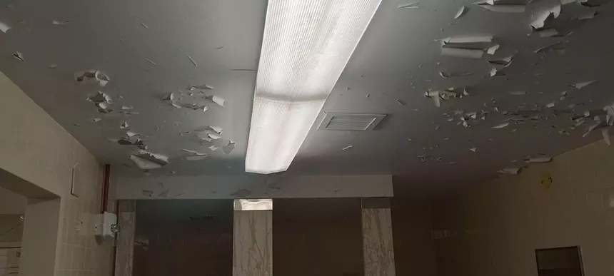 A ceiling finish is peeling off inside a Miami VA bathroom