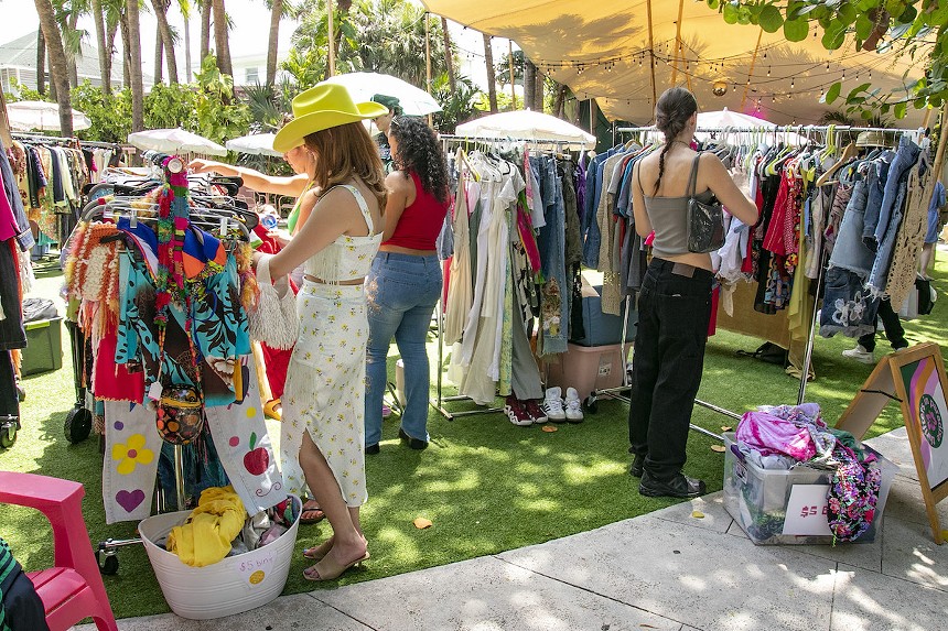 Shoppers sift through racks of blouses and pants at a Miami flea market