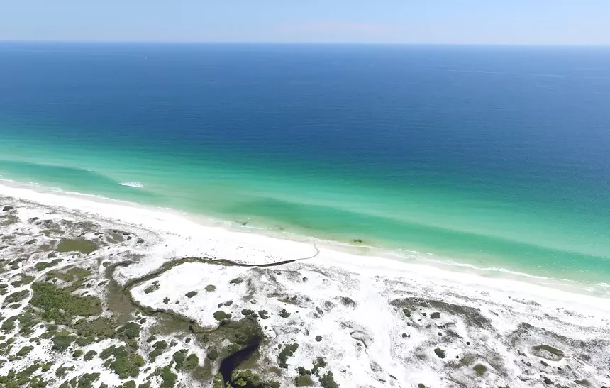 stunning view of dunes, beach, and the emerald and blue waters of the Gulf of Mexico