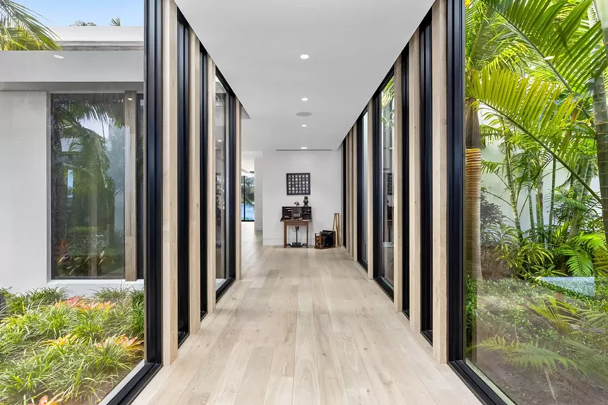 hallway with floor-to-ceiling windows with trees on either side
