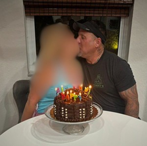 Danny Torres kissing a woman. His neck tattoo is featured.