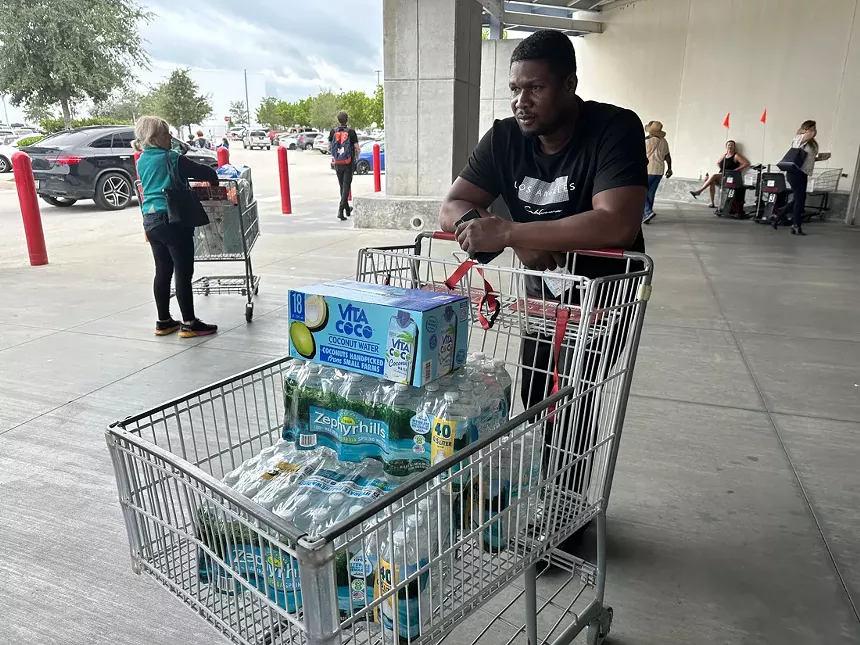 Man pushes a cart filled with water at the Costco in North Miami