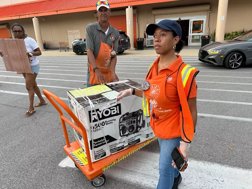Home Depot workers taking a generator to a car