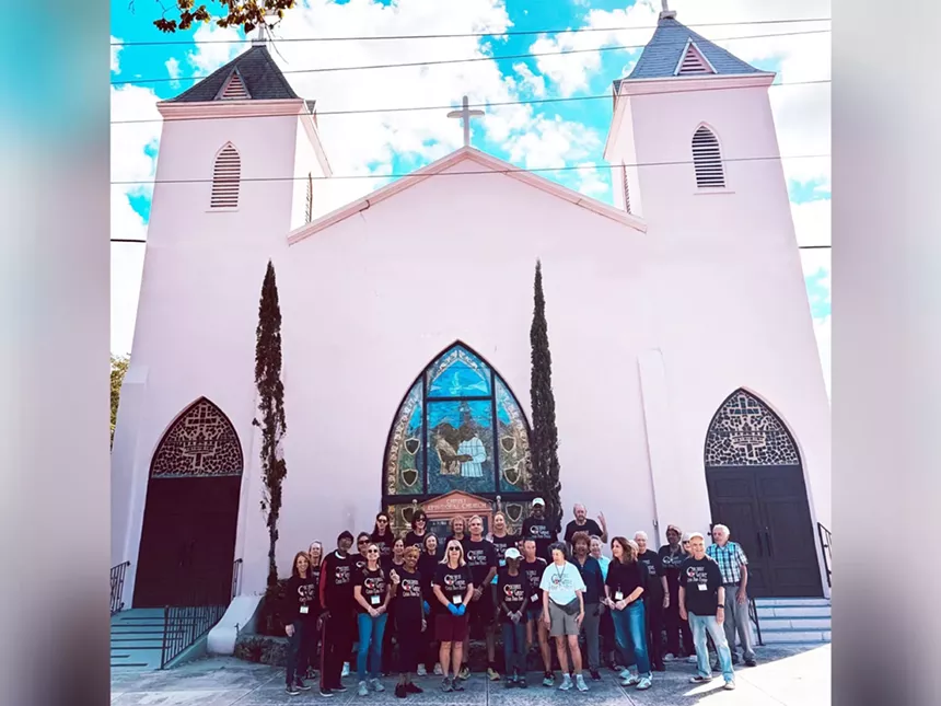 a pink church with people in fornt