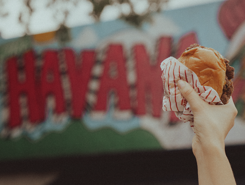 a hand holding a burger