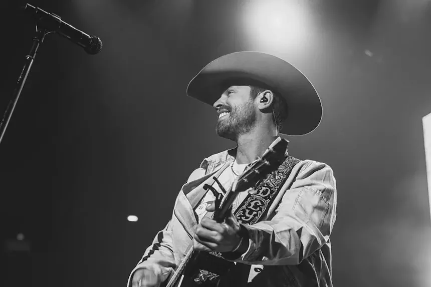 Black and white photo of Dustin Lynch performing onstage