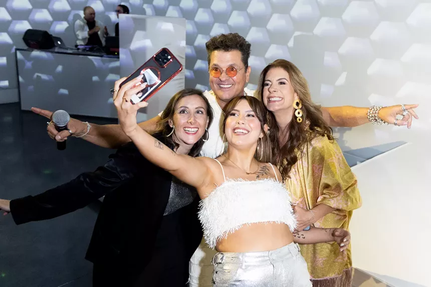 Carlos Vives taking a selfie with three women