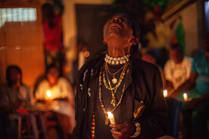 A photo by Woosler Delisfort capturing a Haitian Vodou practitioner in a moment of ancestral communion