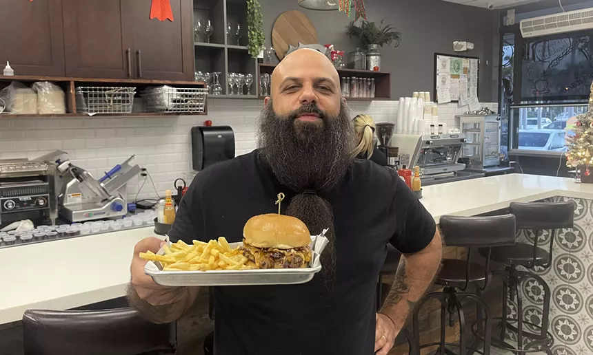 a man in a black t-shirt holding a plate of food