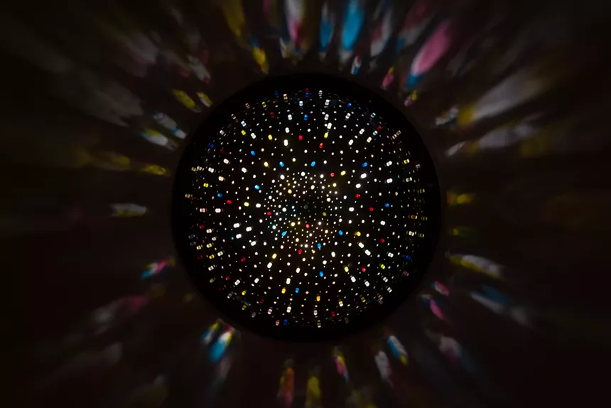 colorful lights peeking through a black orb
