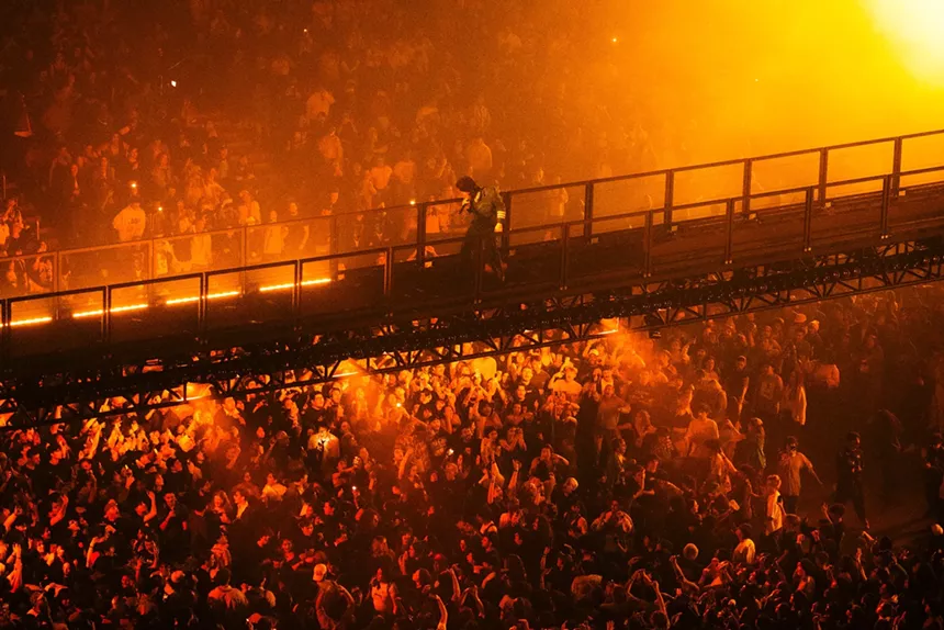 Tyler the Creator walking on the catwalk above the crowd at the Chromakopia Tour in Los Angeles