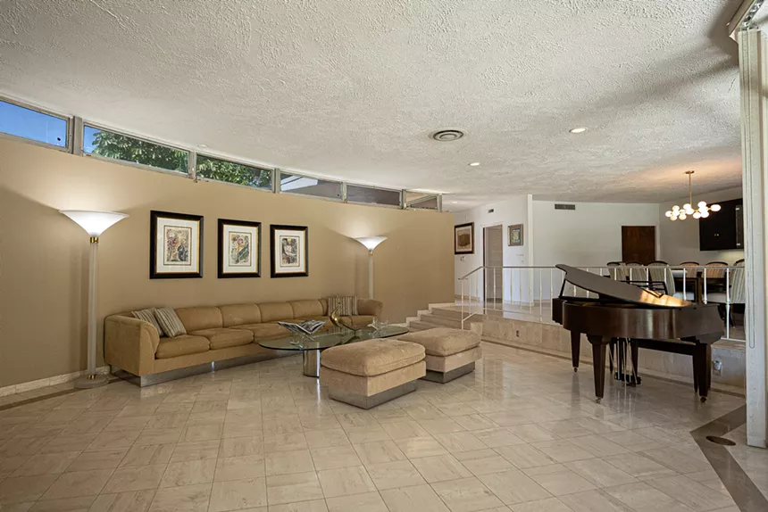 A living room featuring tan curved walls and transom windows