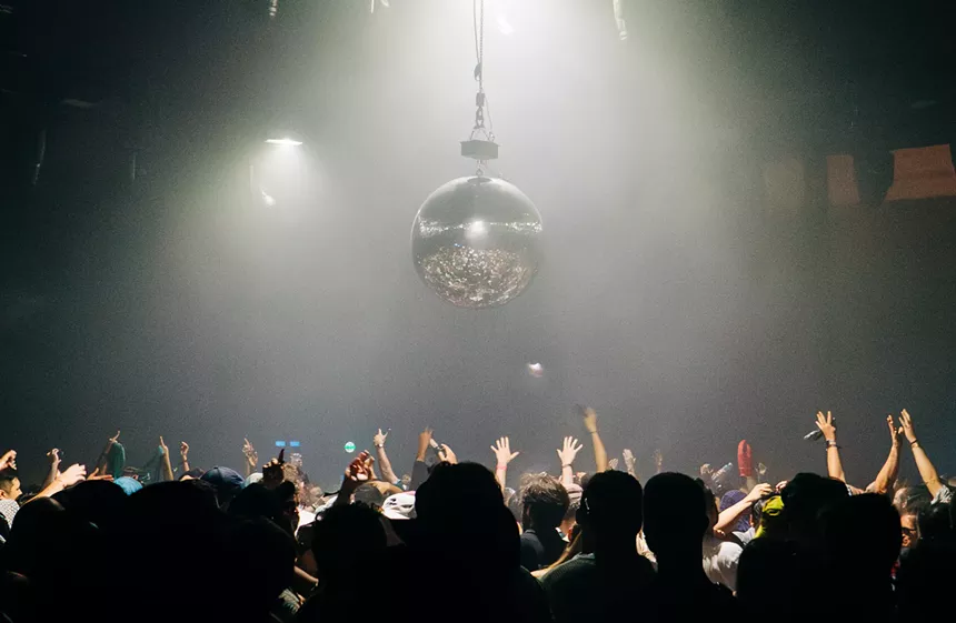 a disco ball and a crowd of EDM fans