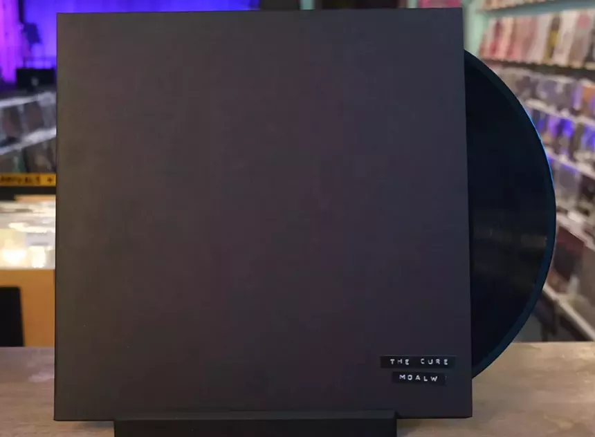 an acetate in a very plain black album cover adorned only with two small strips of stick-on label tape that reads "THE CURE" and, beneath that, "M O A L W"