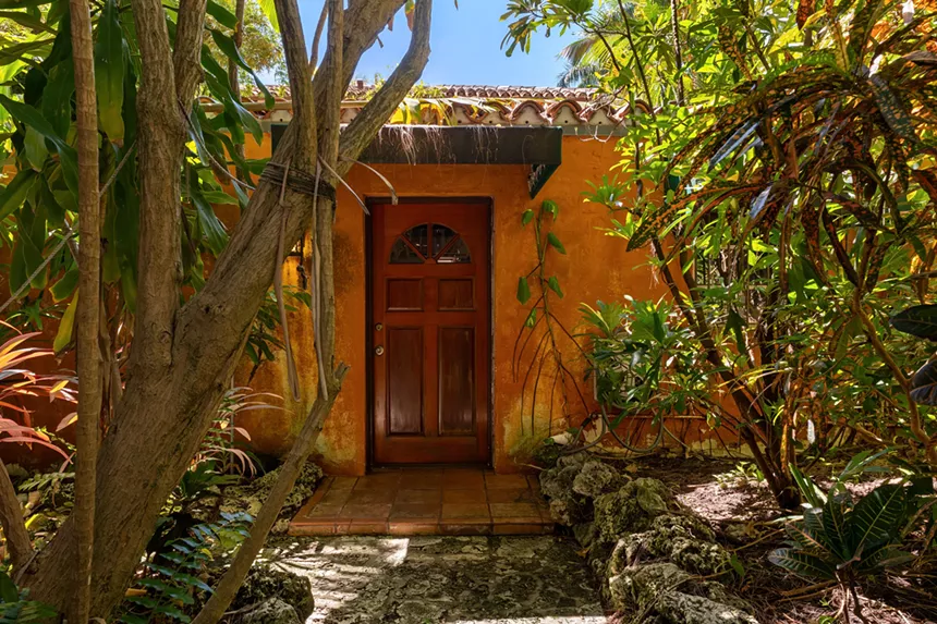 The orange guest cottage with a red door