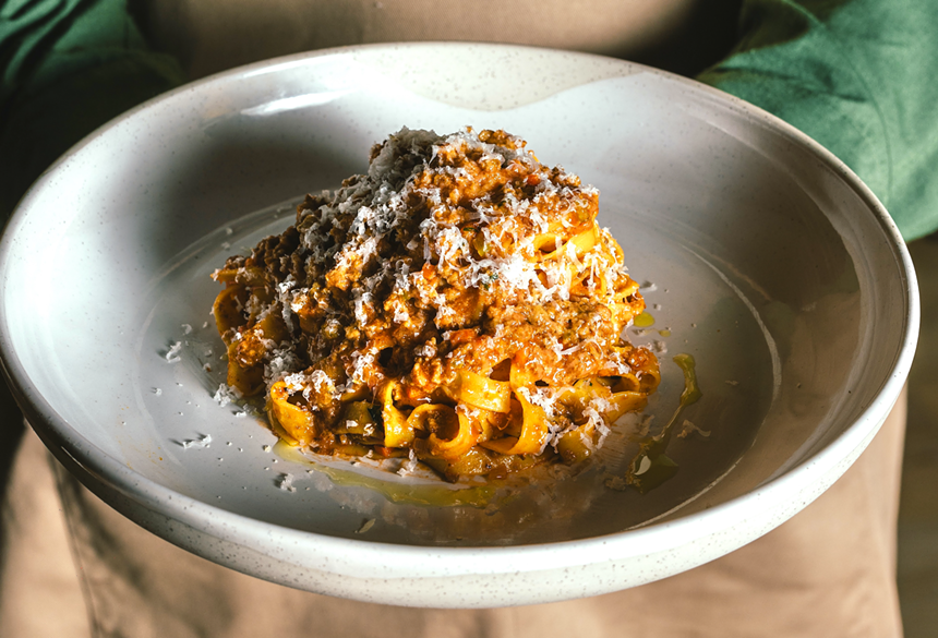 a meat pasta with cheese shavings