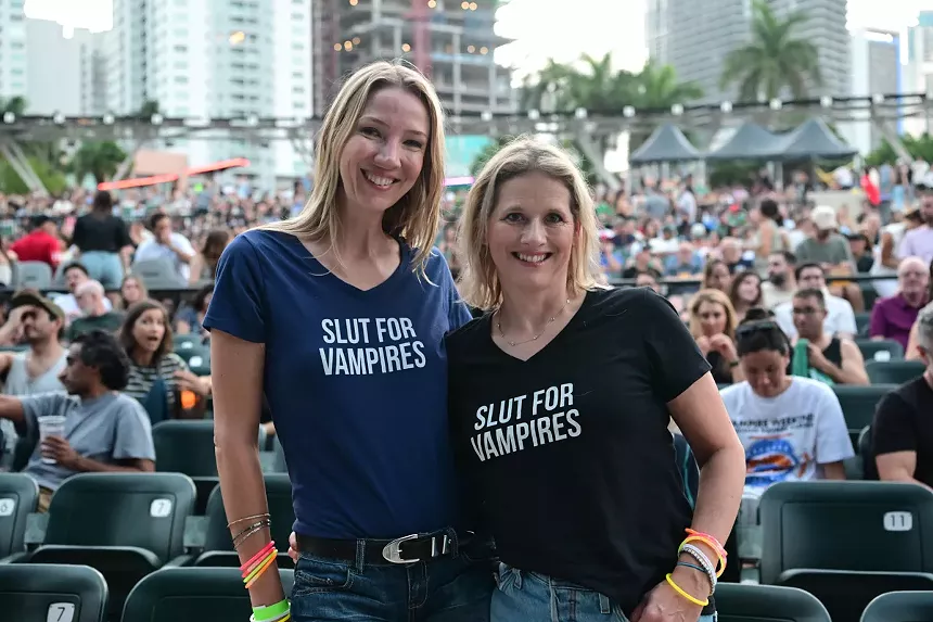 two women wearing matching T-shirts that say Slut For Vampire Weekend