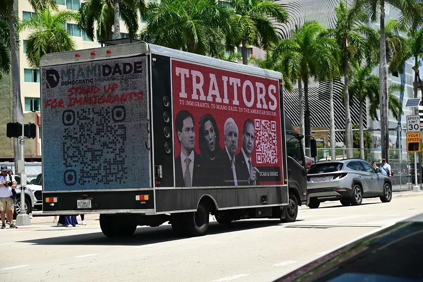 A mobile billboard reading "Traitors" with photos of Florida Republican politicians