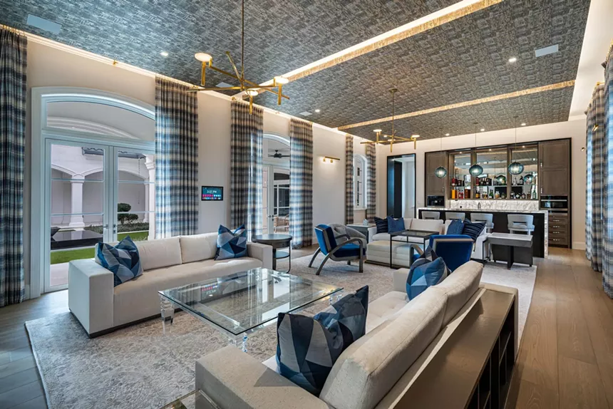 The living room of the estate, decorated with three sofas and a glass table.