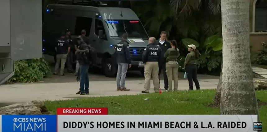 Federal agents gather near a vehicle outside rapper and producer Sean Combs' home.