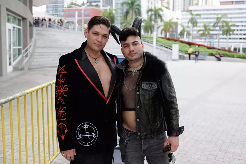 Two people wearing costumes with horns in Miami.
