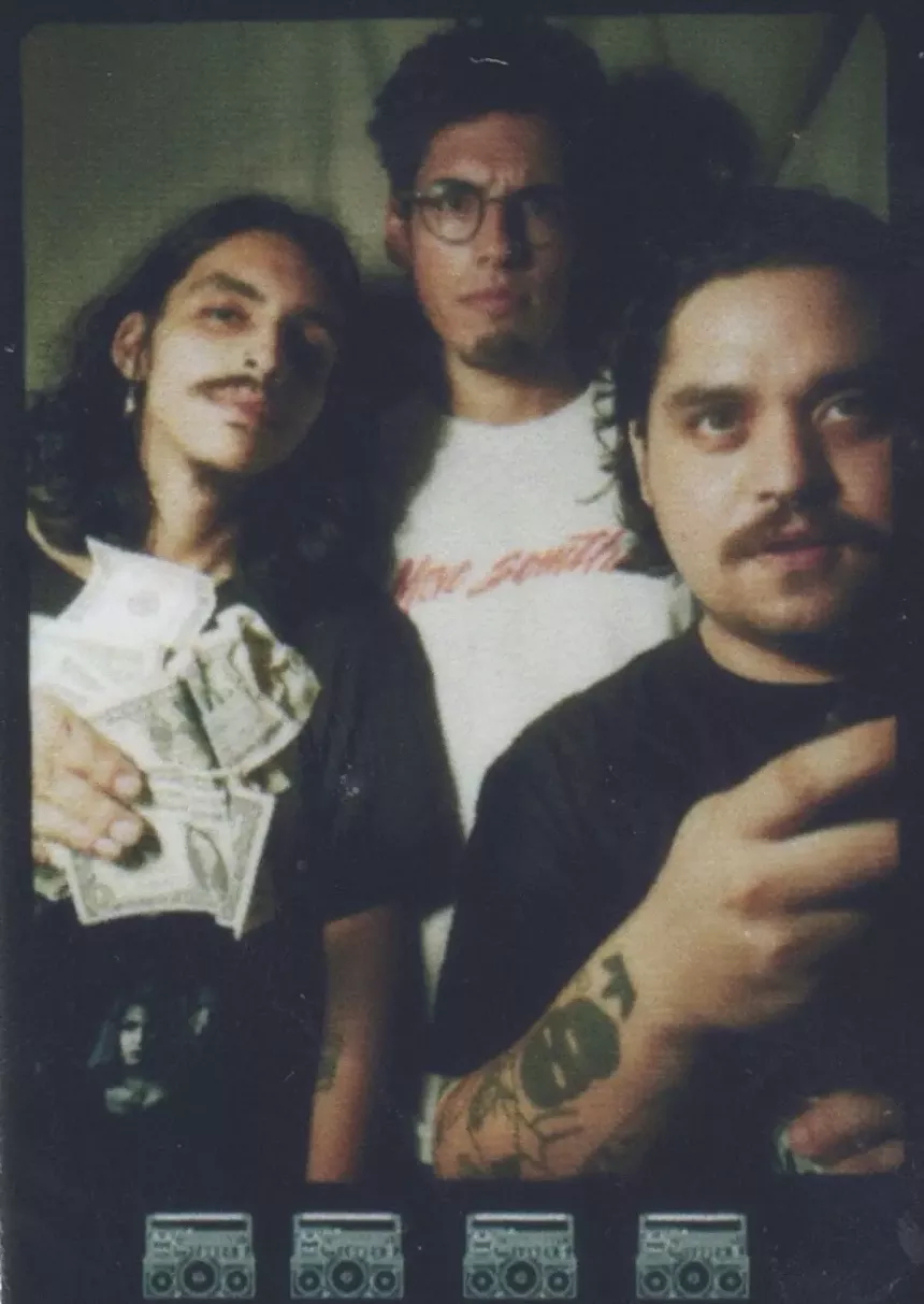 Portrait of three young men holding money.