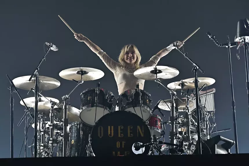 A drummer on stage wearing white.