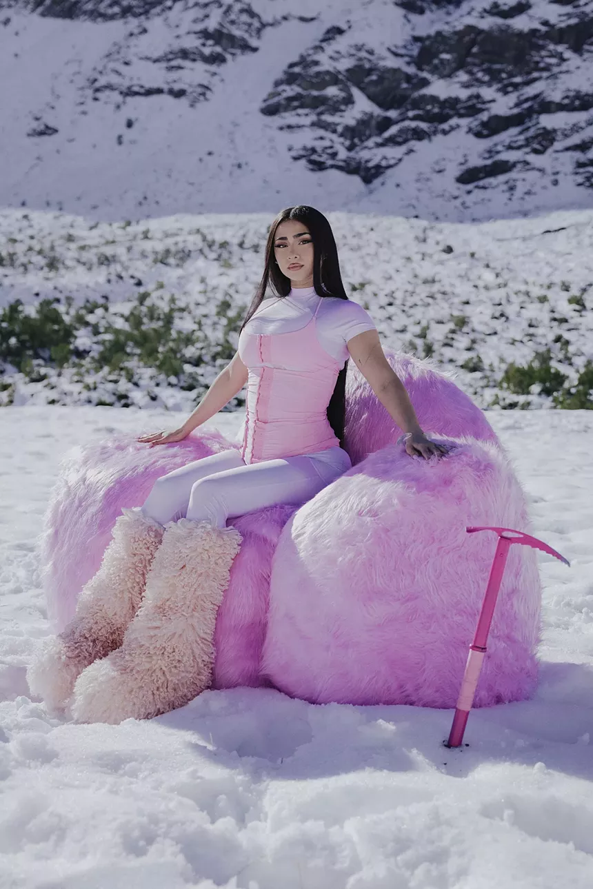 Picture of a woman wearing pink sitting on snow.