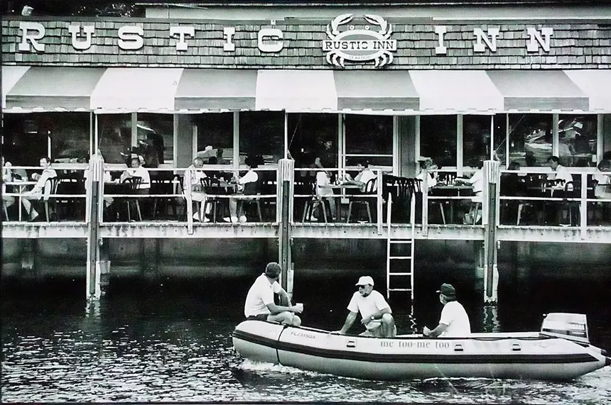 a black and white photograph of men in front of a restaurant