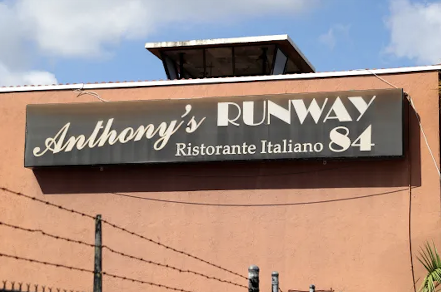 a sign that reads "Anthony's Runway 84" outside of an orange building