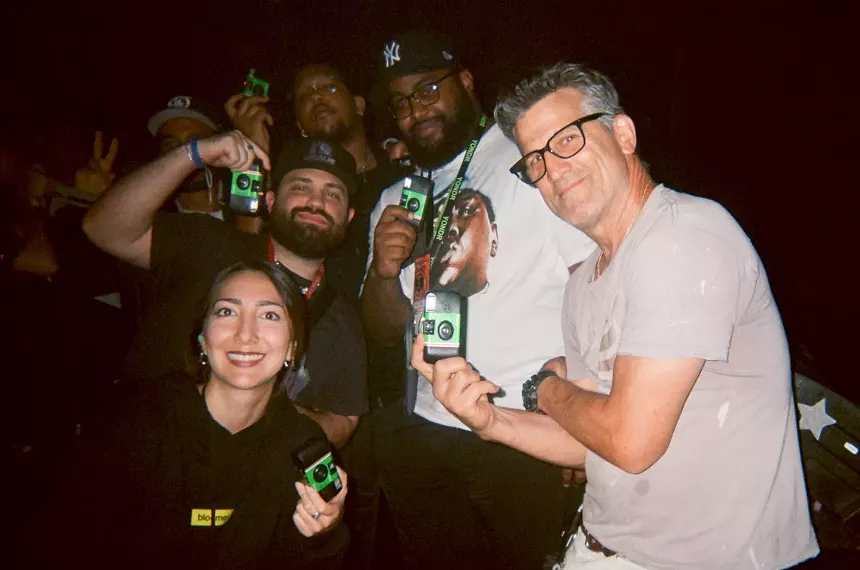Photographers posing with disposable cameras at an Erykah Badu concert.